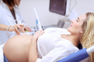 doctor performing ultrasound on pregnant woman