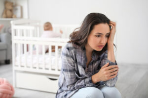 Young woman suffering from postnatal depression at home