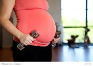 Pregnant woman holding dumbbells