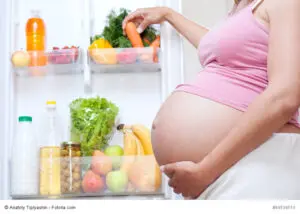 pregnant woman and refrigerator with health food