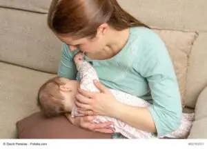 Young mother breast feeding her baby at home