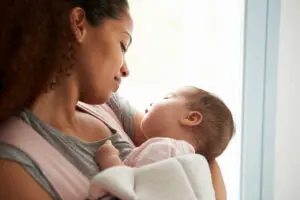 Woman holding her baby to her chest