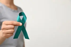 Woman holding cervical cancer ribbon. 