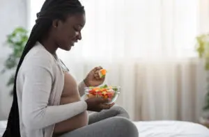 Pregnant woman eating fruit. 