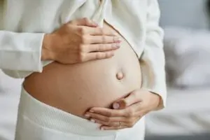 pregnant woman holding stomach.