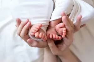 mother holding twin babies feet. 