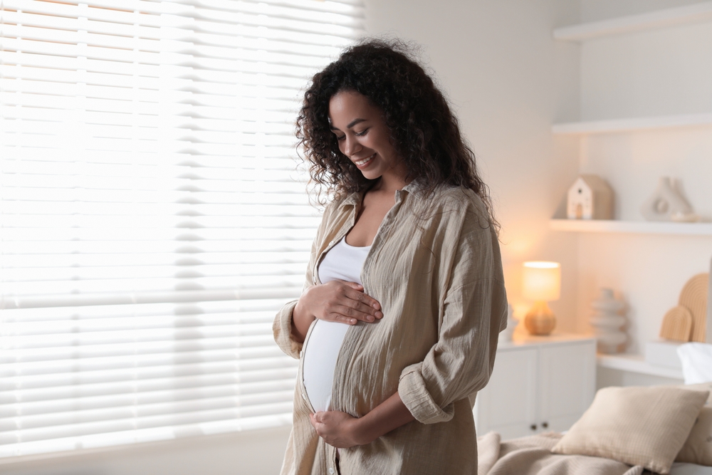 pregnant woman near window at home